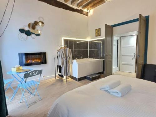 ein Schlafzimmer mit einem Bett und ein Badezimmer mit einer Badewanne in der Unterkunft Suite bien être - jacuzzi et sauna / love room in Arpajon