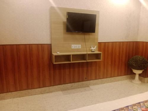 a television on a wall in a room at Hotel Aadhya & Resataurant in Auraiya