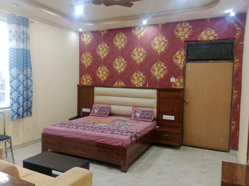 a bedroom with a bed with a purple wall at Hotel Aadhya & Resataurant in Auraiya