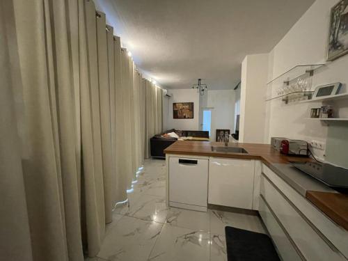 a kitchen with white counters and curtains in a room at NEU! Moderne FeWo Blumenhaus in Idar-Oberstein