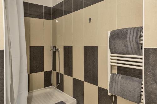 a bathroom with a black and white tiled wall at Casa Santa Maria in Lucciana