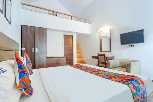 a bedroom with a large white bed and a television at FabExpress Le Aham Boutique in Puducherry