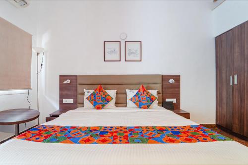 a bedroom with a large bed and a chair at FabExpress Le Aham Boutique in Puducherry