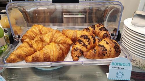 a display case of croissants and other pastries at Blu Hotel in Buccinasco