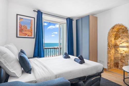 une chambre avec un lit avec vue sur l'océan dans l'établissement Les Sablettes - Cosy studio vue mer, vieux Menton, à Menton