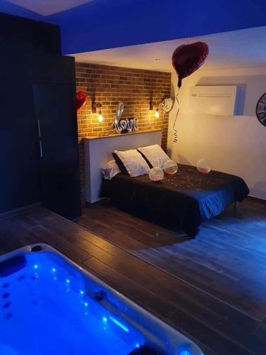 a bedroom with a bed and a hot tub at chambre romantique avec spa privatif in Ferrière-la-Grande