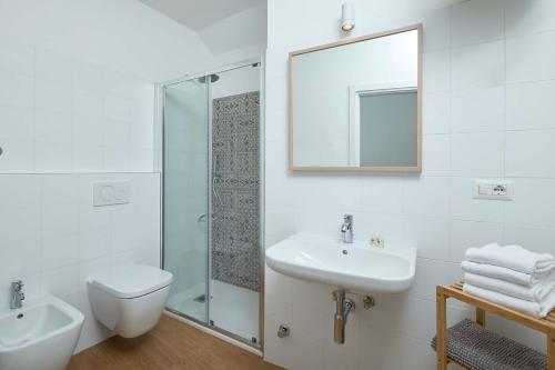 bagno con lavandino, servizi igienici e specchio di Casa Morellato a Riva del Garda