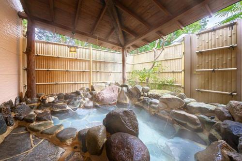 a pool of water with rocks in a backyard at LINKAGE STAY HAKONE SENGOKUHARA in Hakone