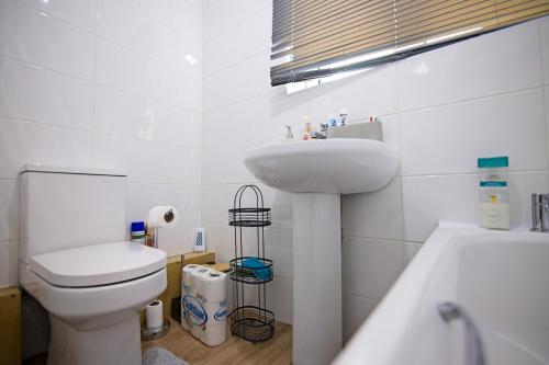 a bathroom with a sink and a toilet and a tub at Sweet Dream Lodge in Manchester