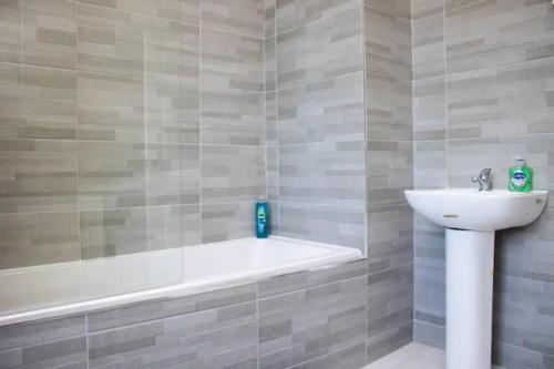 a bathroom with a bath tub and a sink at Suite 3: Sleek Spot near Anfield Stadium in Liverpool