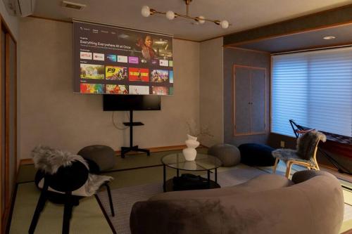 a living room with a couch and a large screen at LINKAGE STAY HAKONE SENGOKUHARA in Hakone