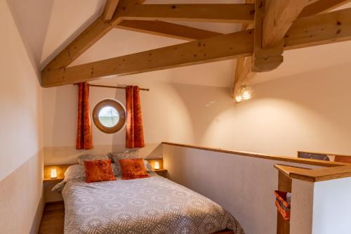 sypialnia z łóżkiem z pomarańczowymi poduszkami w obiekcie Les Treilles de Razac w mieście Razac-de-Saussignac