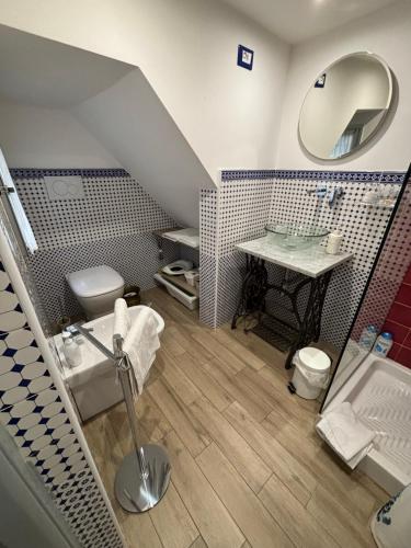 ein Badezimmer mit einem Waschbecken, einem WC und einem Spiegel in der Unterkunft Trentapassidairolli in Genua