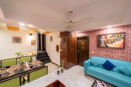 salon z niebieską kanapą i ceglaną ścianą w obiekcie The Lime Stays Greater Kailash Metro nearby Saket Select City w Nowym Delhi