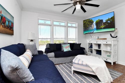 Una sala de estar con un sofá azul y un televisor. en Bucket List by Pristine Properties Vacation Rentals, en Mexico Beach