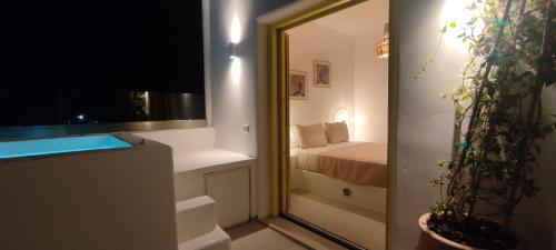 Zimmer mit einem Schlafzimmer mit einem Bett und einem Spiegel in der Unterkunft New Earth in Kamari