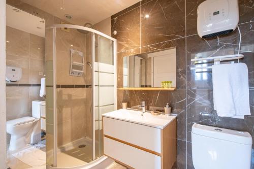 ein Bad mit einer Dusche, einem Waschbecken und einem WC in der Unterkunft Studio Marron - Paris à 10 min - RER in Deuil-la-Barre
