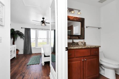 a bathroom with a sink and a toilet and a mirror at Bucket List by Pristine Properties Vacation Rentals in Mexico Beach