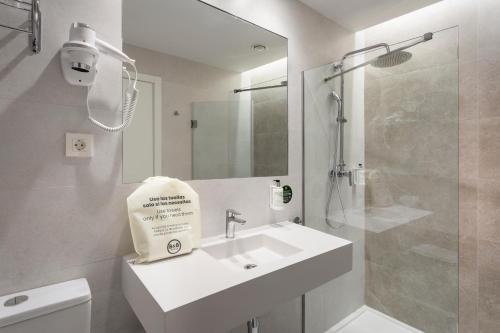 bagno bianco con lavandino e doccia di B&B HOTEL Écija a Écija