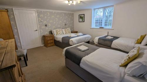 a bedroom with three beds and a desk and a table at East Ayton Lodge Hotel, Scarborough in Scarborough