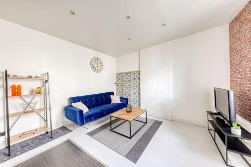 a living room with a blue couch and a tv at Superbe logement près de la gare et de l'autoroute in Savigny-sur-Orge