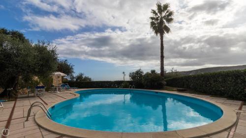 een zwembad met een palmboom op de achtergrond bij Italianway - Il Borgo apartments in Finale Ligure