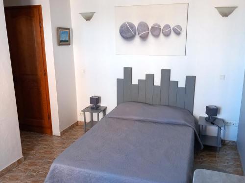 a bedroom with a bed and a picture on the wall at La Tour Fondue Appartement vue mer Grand T2 face a Porquerolles Drap serviette non fournis in Hyères