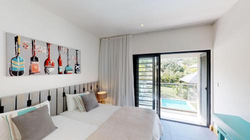 a bedroom with a white bed and a window at Marguery Villas in Rivière Noire