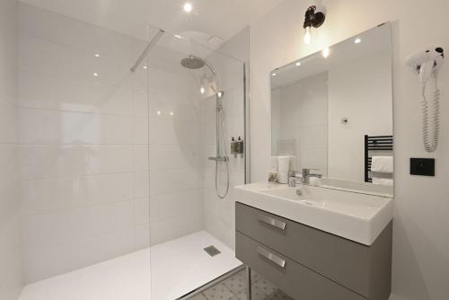 biała łazienka z umywalką i prysznicem w obiekcie Manoir de l'évêché w mieście Lisieux