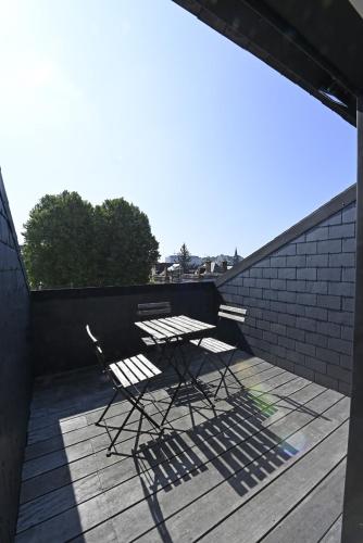 a picnic table and chairs sitting on a deck at Manoir de l'évêché et Spa in Lisieux