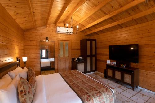 a bedroom with a bed and a flat screen tv at Canary Islands Resort & Spa in Lonavala