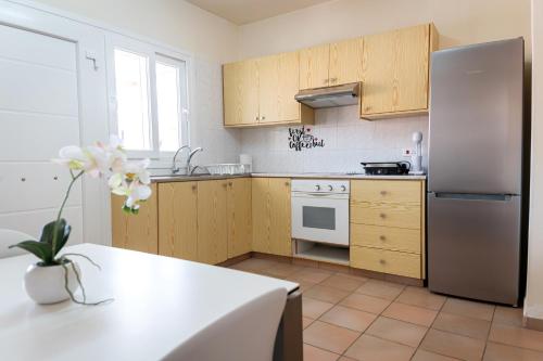 a kitchen with wooden cabinets and a stainless steel refrigerator at Hubstay - Hillside Home in Platres in Platres