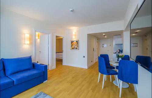 ein Wohnzimmer mit blauen Stühlen und einem Tisch in der Unterkunft PANORAMA Orbi Beach Resort Center Suite in Batumi