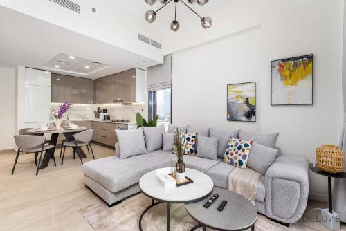 a living room with a couch and a table at Comfy 1BR in Azizi Riviera 8, Al Merkadh by Deluxe Holiday Homes in Dubai