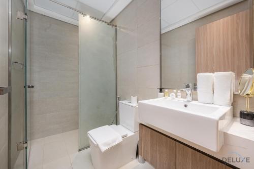 a bathroom with a toilet and a sink and a shower at Comfy 1BR in Azizi Riviera 8, Al Merkadh by Deluxe Holiday Homes in Dubai