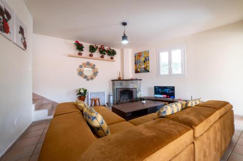 a living room with a couch and a fireplace at Hubstay - Hillside Home in Platres in Platres
