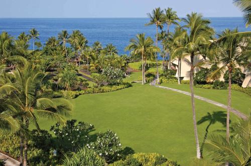 an aerial view of a lawn with palm trees and the ocean at OUTRIGGER Kona Resort and Spa in Kailua-Kona