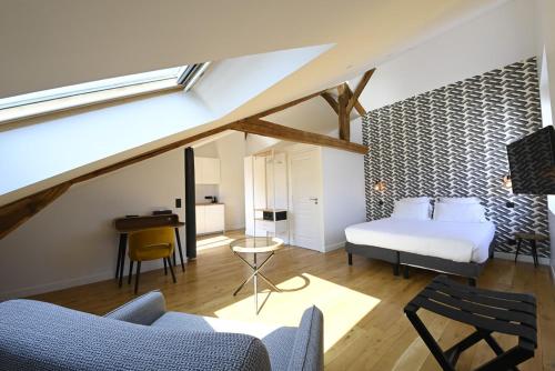 a bedroom with a bed and a desk in a room at Manoir de l'évêché et Spa in Lisieux
