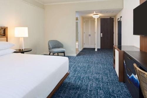 a hotel room with a bed and a desk and chair at OUTRIGGER Kona Resort and Spa in Kailua-Kona