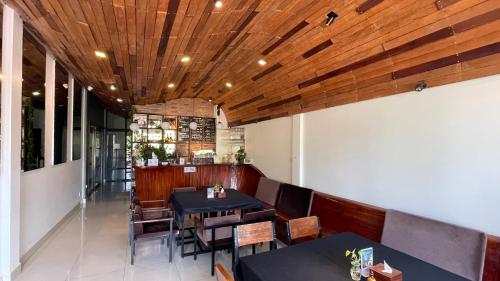 a restaurant with tables and chairs and a wooden ceiling at Rocky Cafe & Mini Apartment in Siem Reap