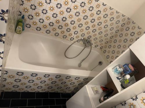 a white bath tub in a bathroom with floral wallpaper at Résidence Europe in Brussels