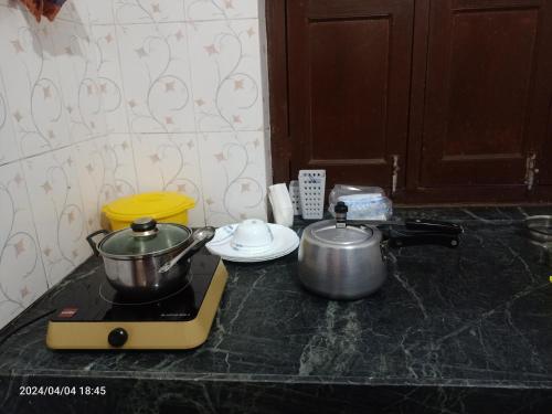 a stove top with two pots and pans on it at Gokulam Villa in Udaipur