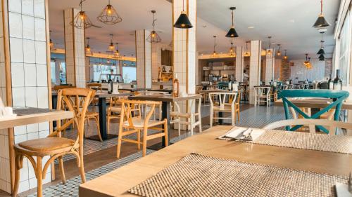 a restaurant with wooden tables and chairs in a room at Labranda Corralejo Village in Corralejo