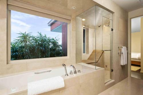 a bathroom with a tub and a large window at Crane Penthouse in Portland