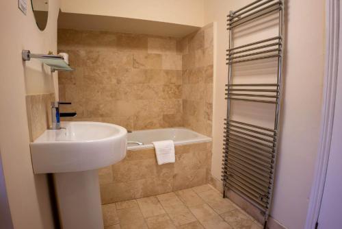 y baño con lavabo y bañera. en East Ayton Lodge Hotel, Scarborough, en Scarborough
