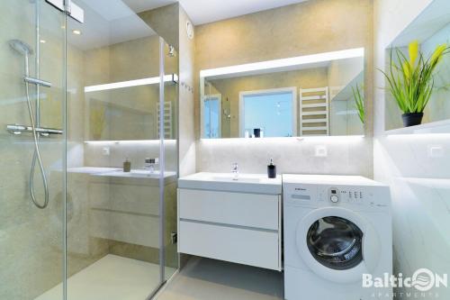 コウォブジェクにあるApartamenty BalticON Westin House -luksusowy 70m2 , basen pool, sauna, parking inklusiveのバスルーム(シンク2台、洗濯機付)