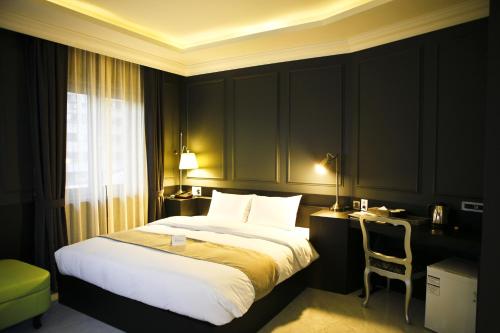 a bedroom with a bed and a desk with a chair at Hotel Doma Myeongdong in Seoul