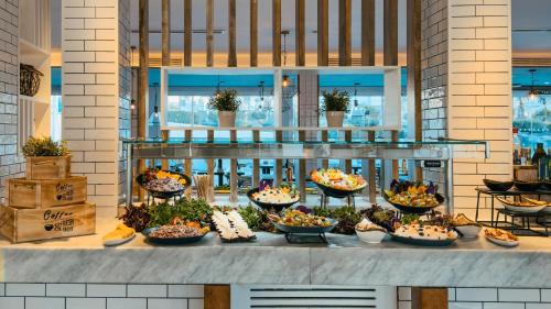 a buffet with many bowls of food on a counter at Labranda Corralejo Village in Corralejo