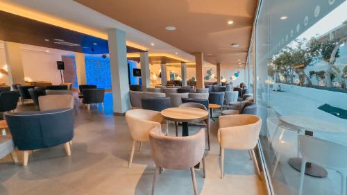 a restaurant with chairs and a table and a bar at Labranda Corralejo Village in Corralejo