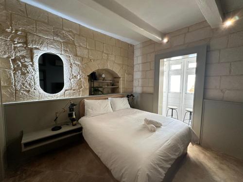 a bedroom with a white bed and a window at Domingo x Casa Norte in Birgu